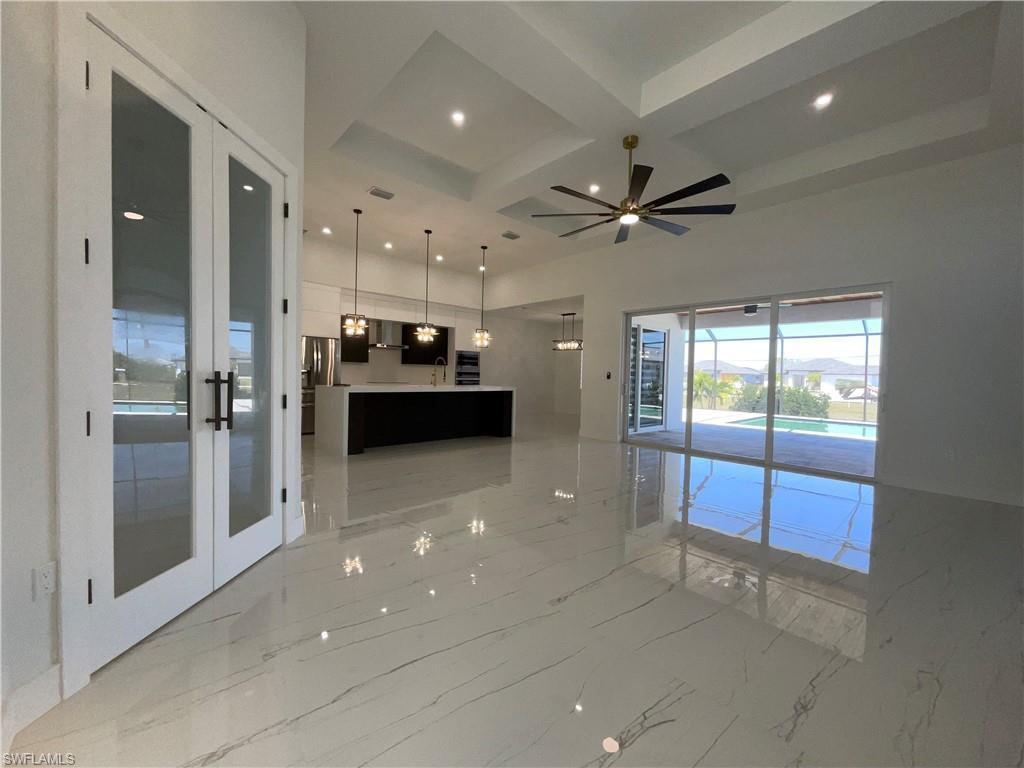 Image 4: Expansive living area with large format tile flooring, a modern ceiling fan, and recessed lighting