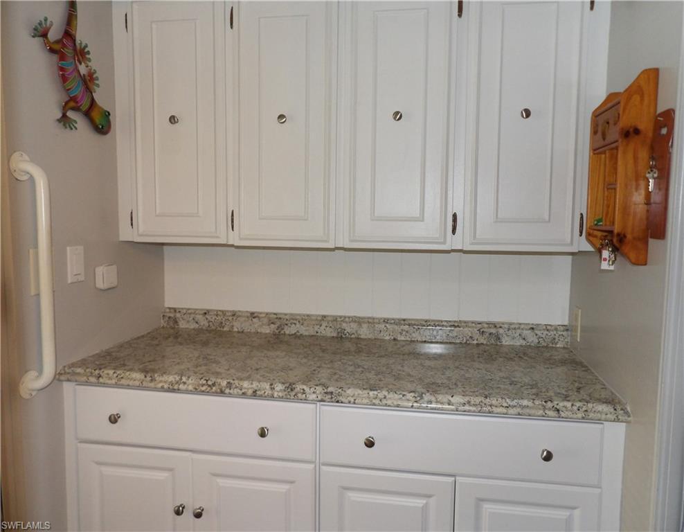 Image 4: Kitchen featuring white cabinetry and light stone counters