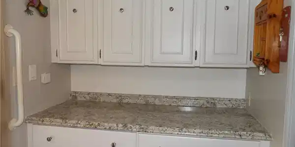 Image 4: Kitchen featuring white cabinetry and light stone counters