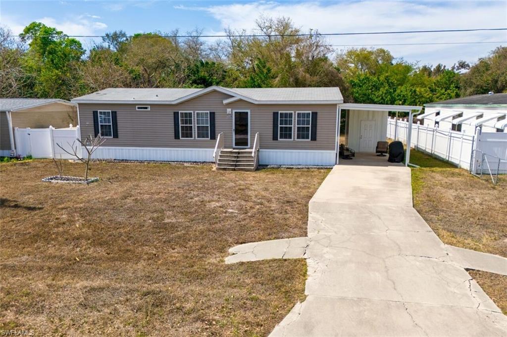 Image 3: Manufactured / mobile home with concrete driveway and a carport