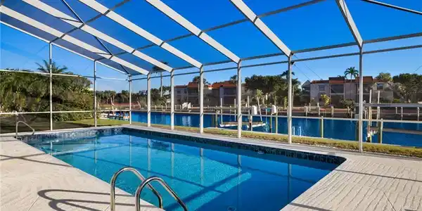 Image 4: Swimming pool with a lanai, a water view, a sunroom, and a boat dock