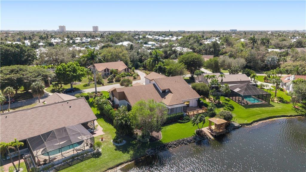 Image 2: Aerial perspective of suburban area with a nearby body of water and a tree filled landscape