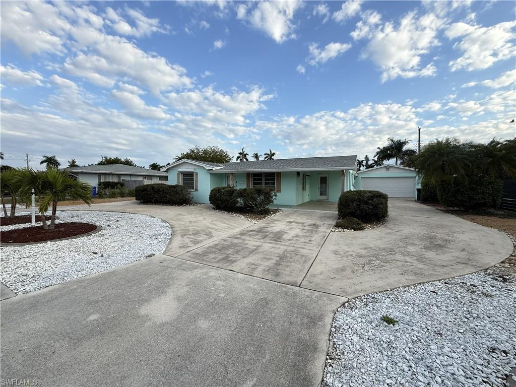 Image 2: Single story home featuring covered porch, curved driveway, and a garage