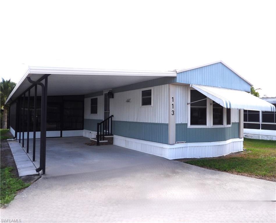 Image 1: View of front of property featuring a sunroom, an attached carport, driveway, and a patio area