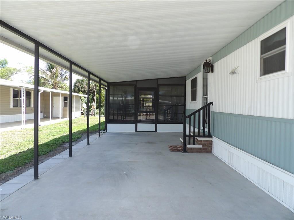 Image 2: View of patio featuring a sunroom and an attached carport