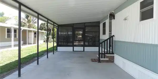 Image 2: View of patio featuring a sunroom and an attached carport