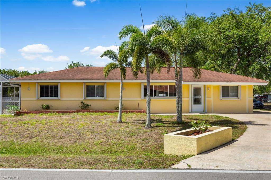 Image 1: Ranch-style home with stucco siding, concrete driveway, screened pool cage.