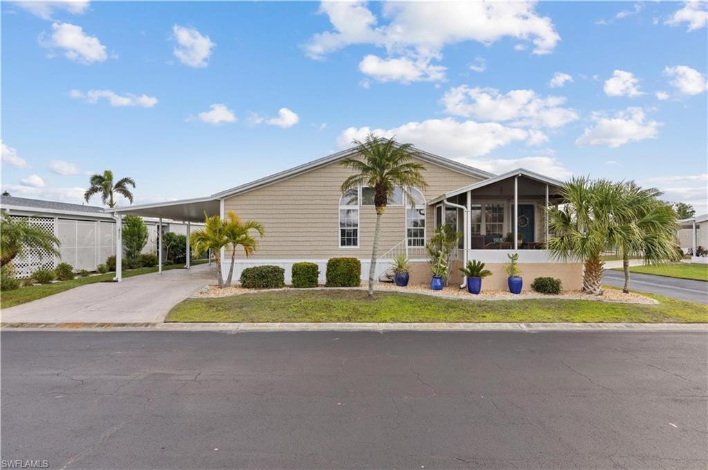 Image 2: Manufactured / mobile home with an attached carport, a sunroom, driveway, and a front yard