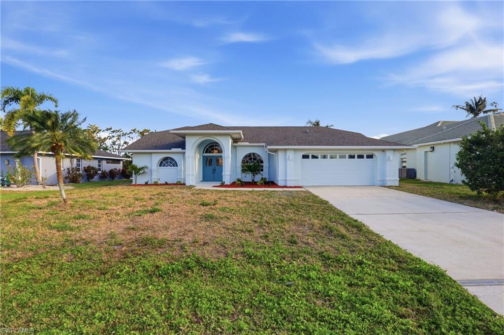 Image 2: Light blue exterior with a dark shingle roof and a two-car garage