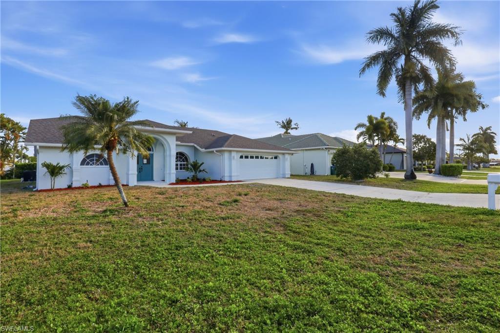 Image 4: Single-story residence featuring a two-car garage and a paved driveway