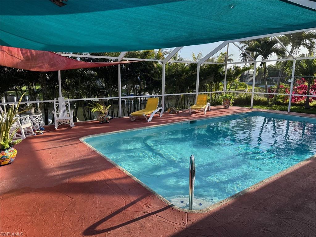 Image 2: Relax in the shade under your blue and red sail and enjoy your heated pool that was resurfaced in 2026.