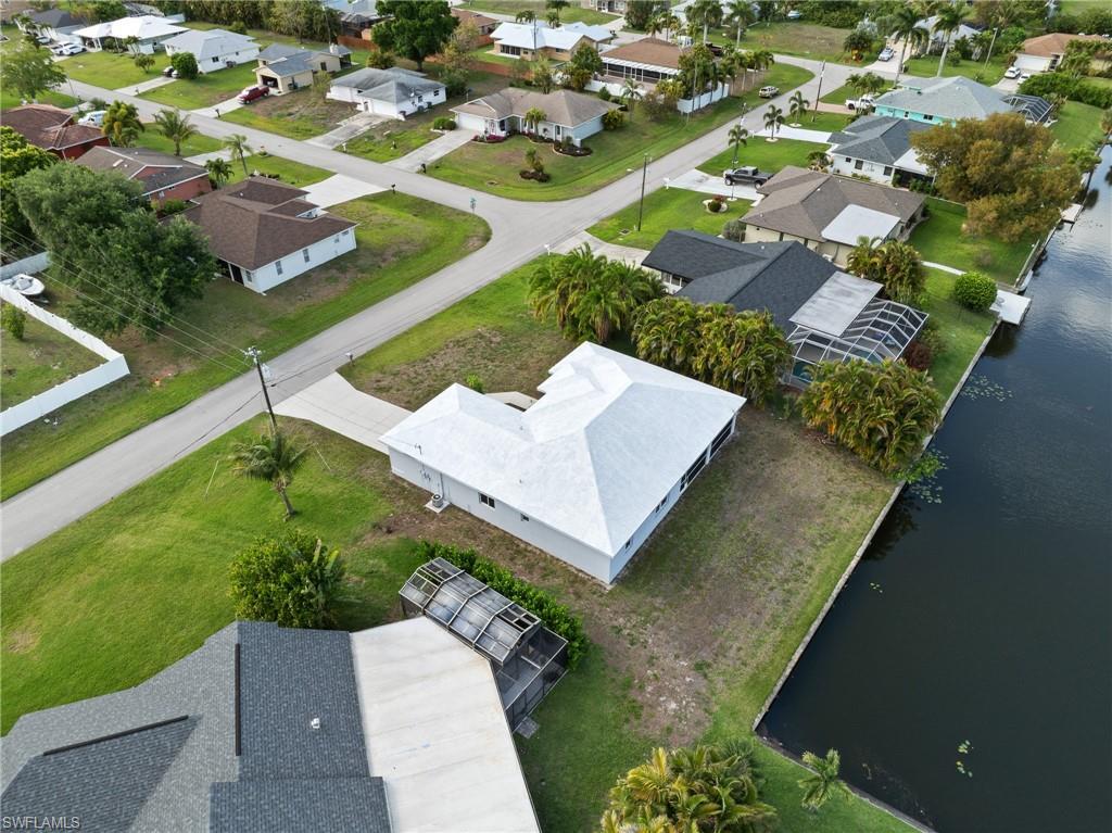 Image 4: Aerial perspective of suburban area featuring a nearby body of water
