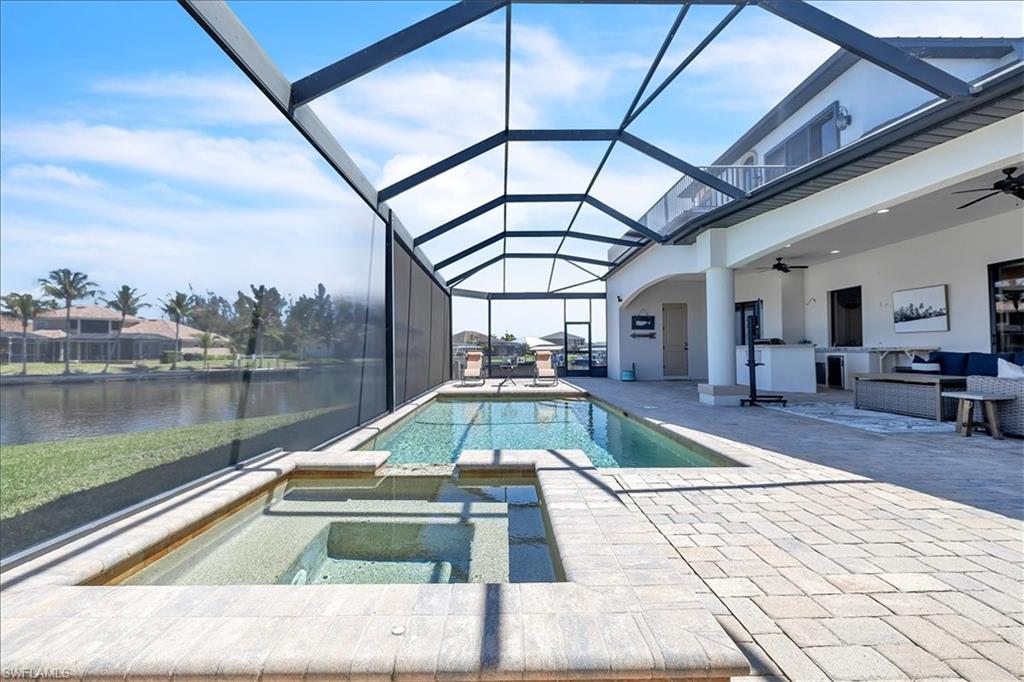 Image 2: Screened lanai featuring a swimming pool and integrated spa