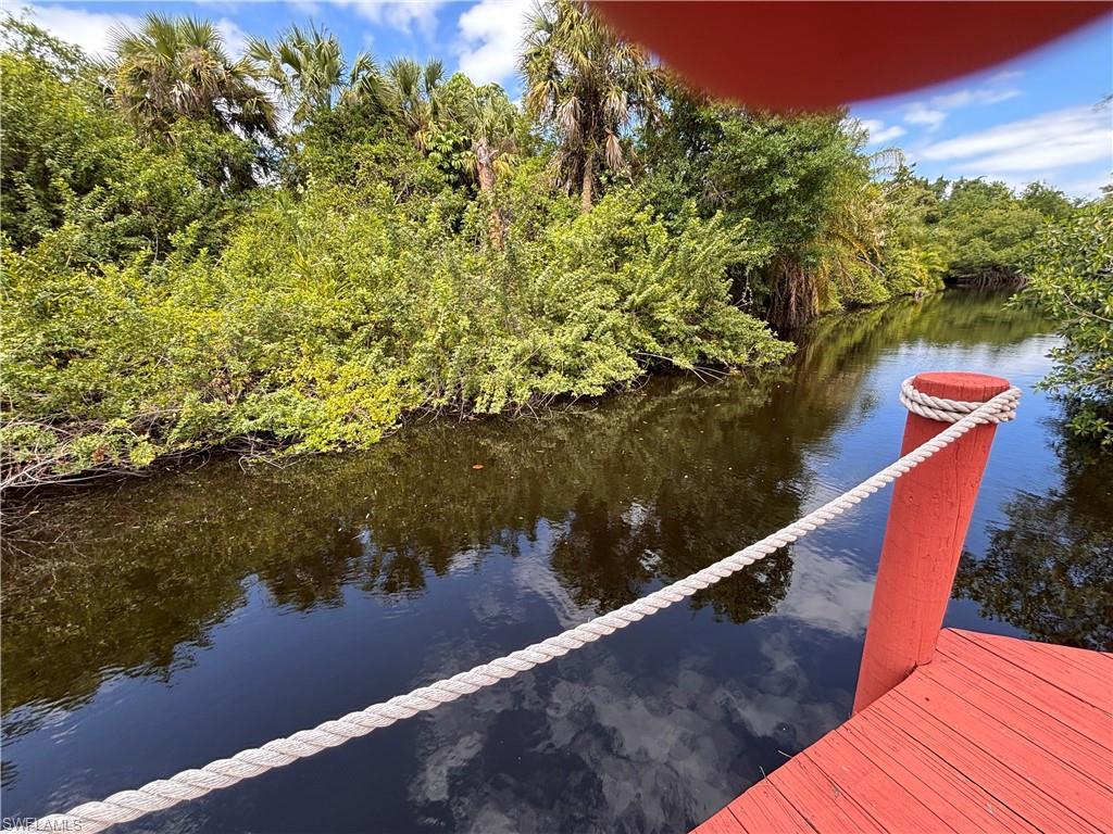 Image 2: Waterfront access with a red-painted dock and a rope railing