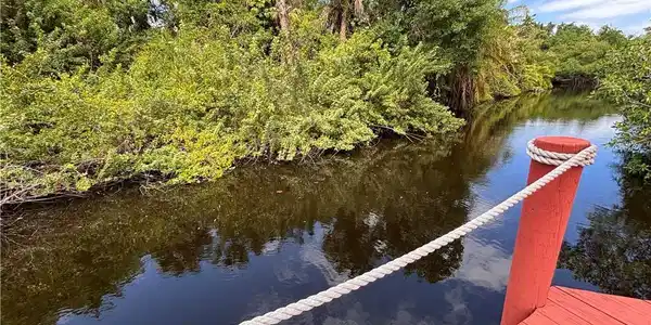 Image 2: Waterfront access with a red-painted dock and a rope railing