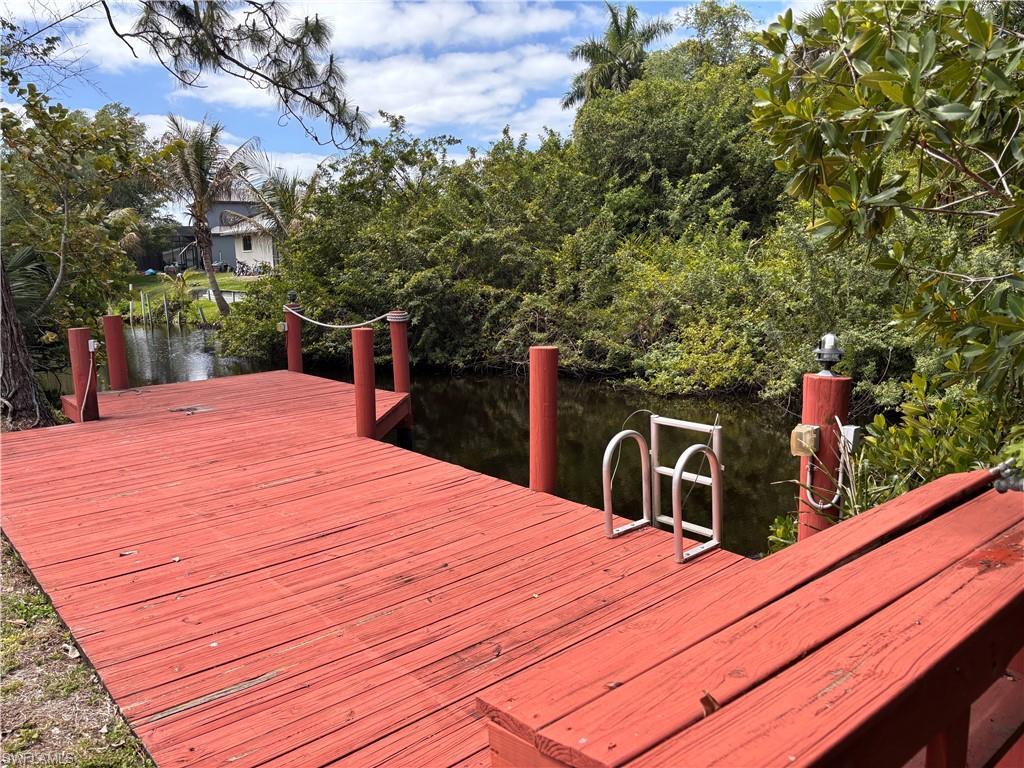 Image 3: The property features a red wooden dock with a rope railing, providing direct access to the canal
