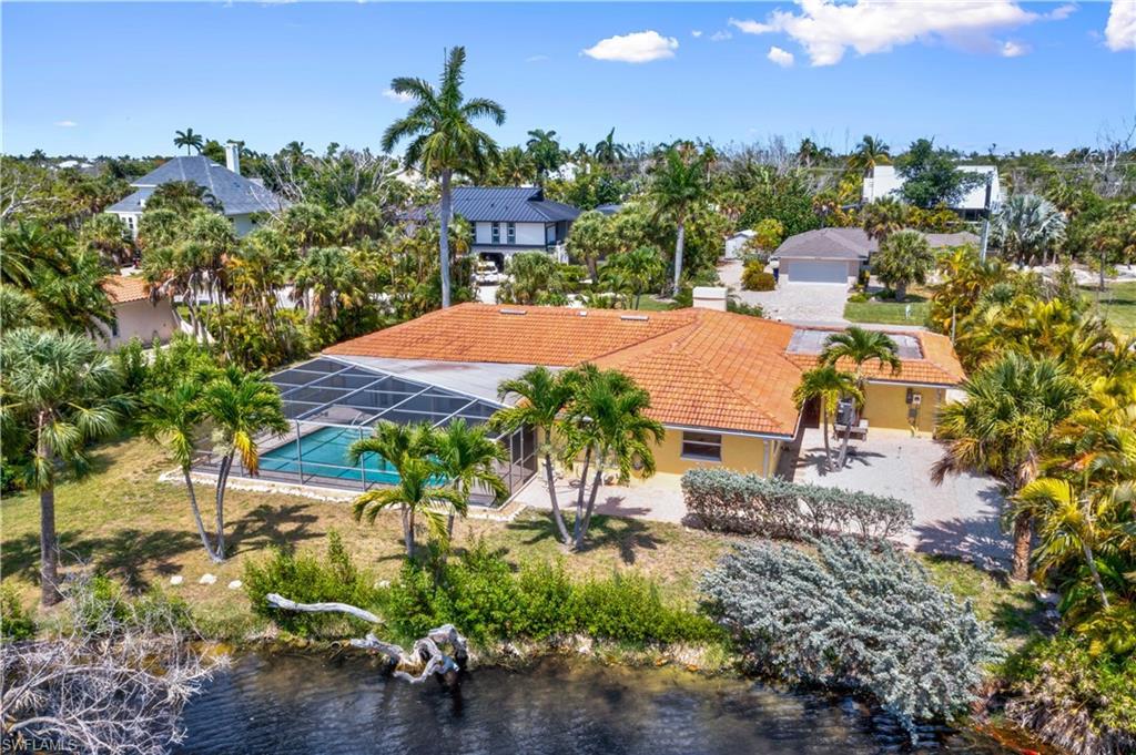 Image 2: Bird&rsquo;s-eye view of the backyard oasis featuring the sparkling pool, spacious lanai, and private landscaped setting.