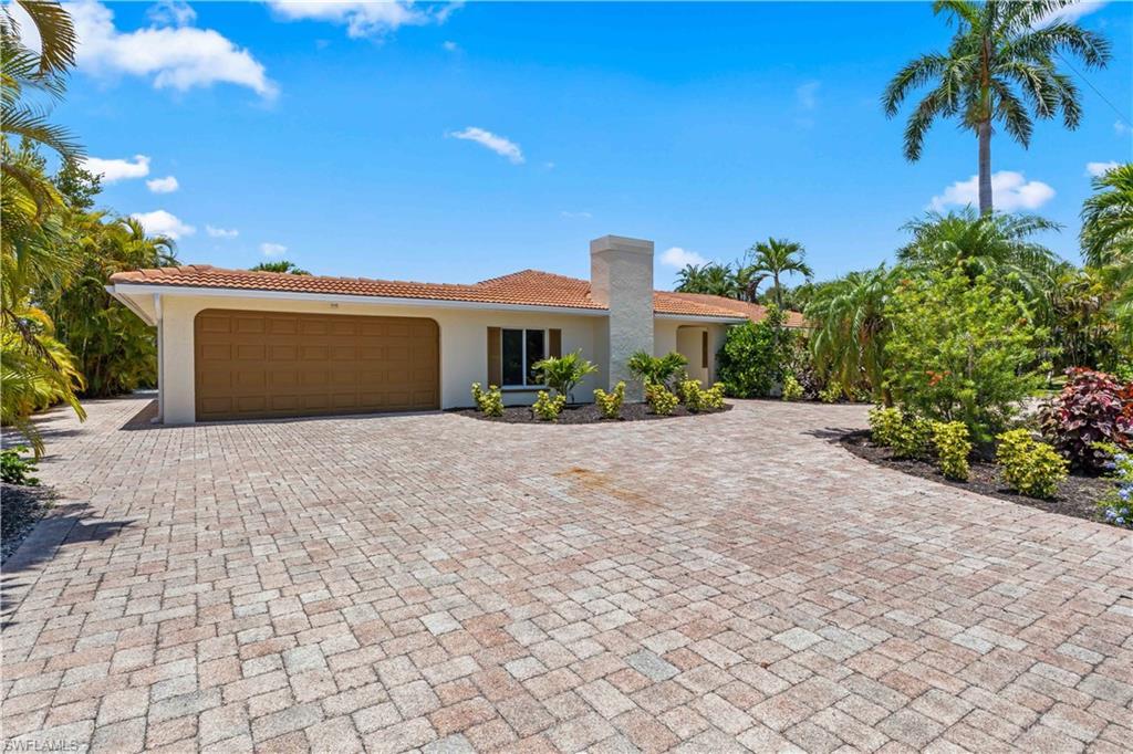 Image 4: Beautifully landscaped front exterior featuring a welcoming courtyard patio and elegant island-inspired design.