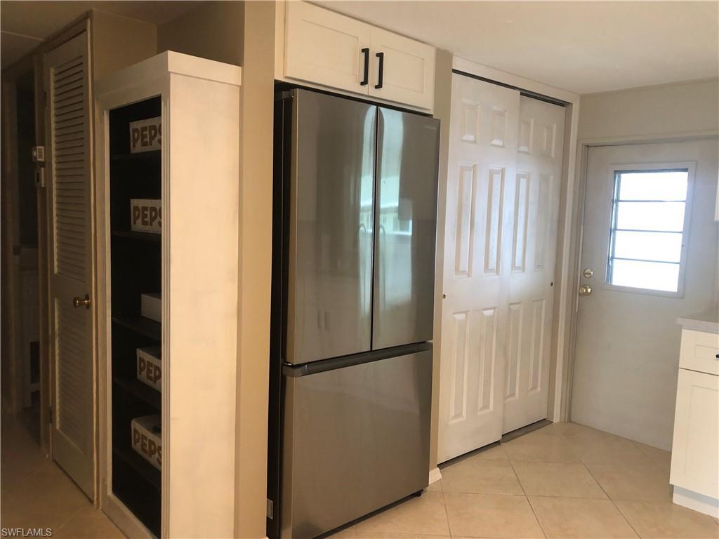 Image 2: Kitchen featuring white cabinetry with quiet close, stainless steel refrigerator, and light tile patterned flooring