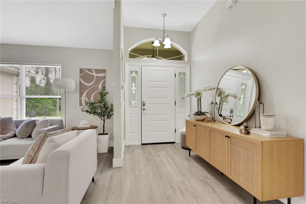 Image 4: Light-filled entryway featuring a paneled front door with decorative sidelights and an arched transom window