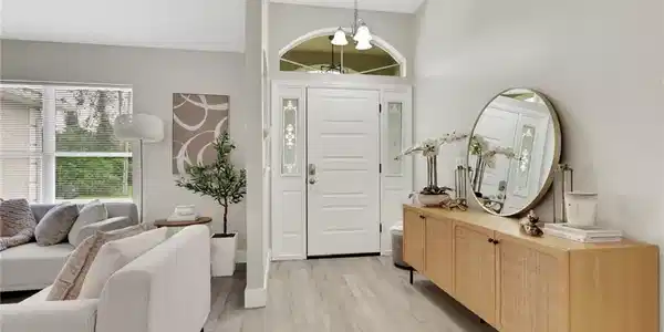 Image 4: Light-filled entryway featuring a paneled front door with decorative sidelights and an arched transom window