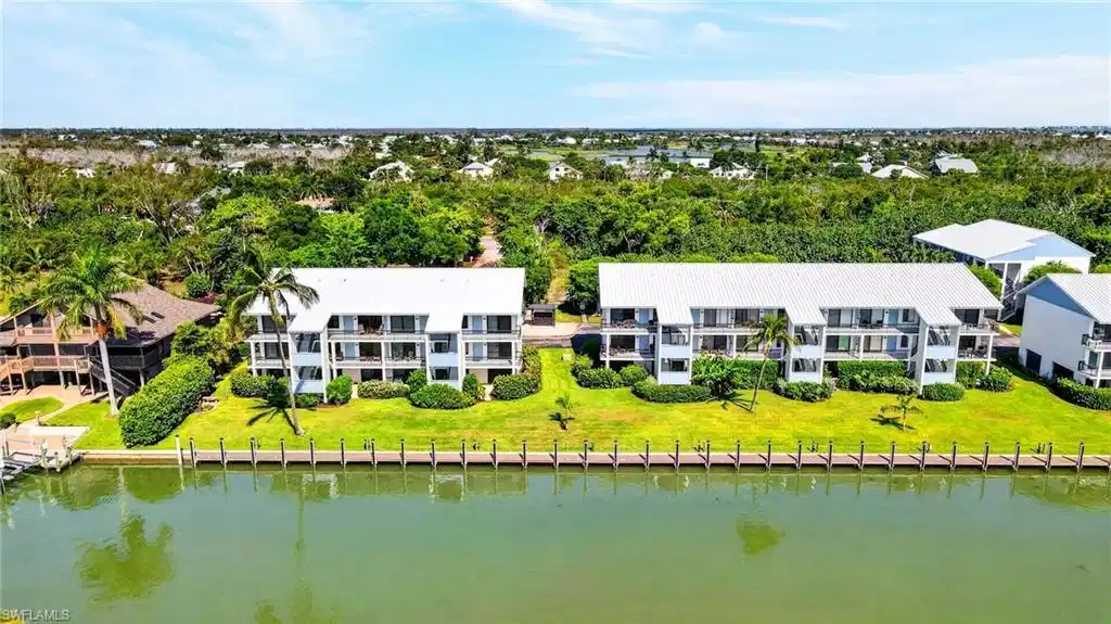Image 1: Waterfront multi-unit property featuring a metal roof and private balconies
