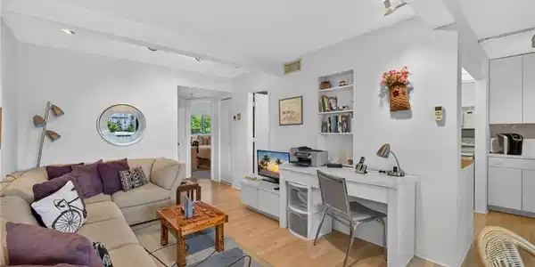 Image 3: Living area featuring light wood-finish flooring, recessed lighting, and a built-in desk with shelving