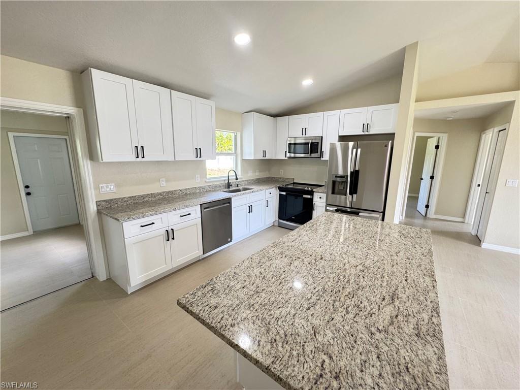 Image 4: Contemporary kitchen featuring a large central island with a granite countertop