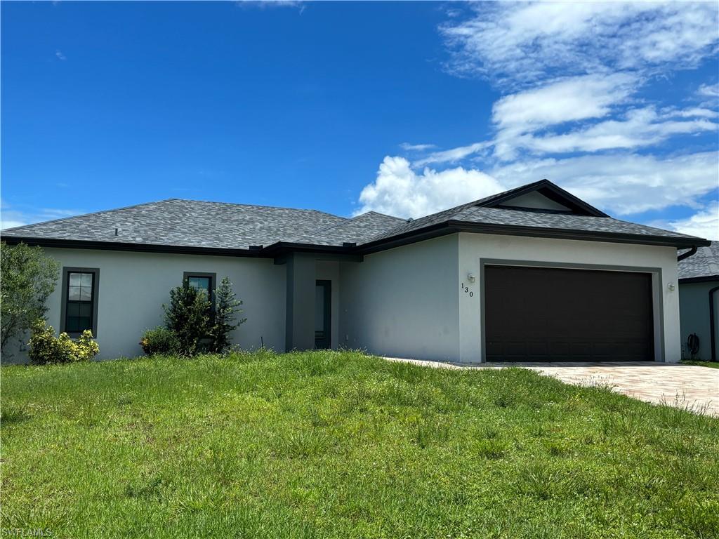 Image 2: View of front of home featuring a garage and a front lawn