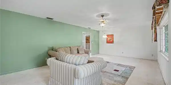 Image 4: Spacious interior featuring a recessed ceiling light fixture, a wide window, and a light-colored carpeted floor