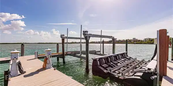 Image 4: Waterfront dock featuring composite decking, multiple pilings, boat lift system, and a floating jet ski dock