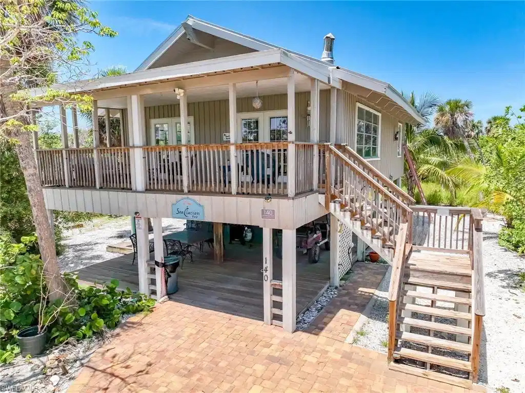 Image 1: View of front of house featuring stairs, a porch, and french doors