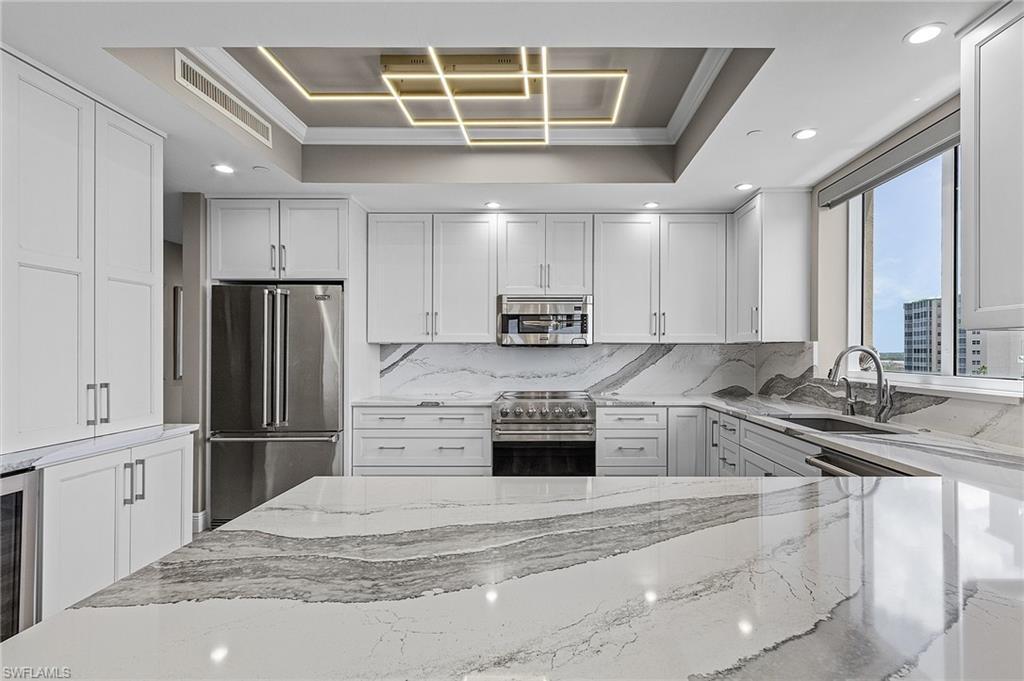 Image 3: Kitchen featuring sink, high quality appliances, a raised ceiling, and ornamental molding