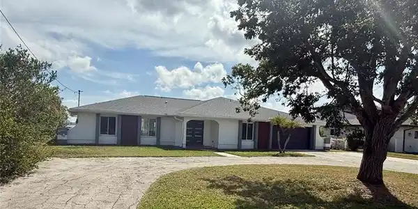 Image 2: Ranch-style house featuring driveway, a front lawn, an attached garage, and stucco siding