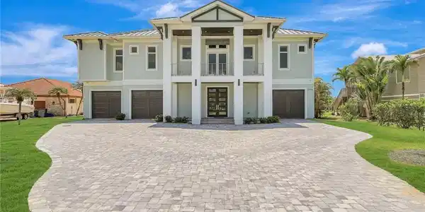 Image 2: View of front of house with a garage, a standing seam roof, and decorative driveway