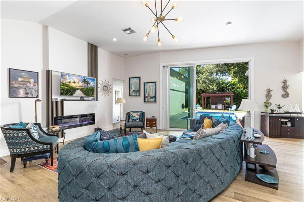 Image 4: Living room with light wood-style floors, a chandelier, and recessed lighting