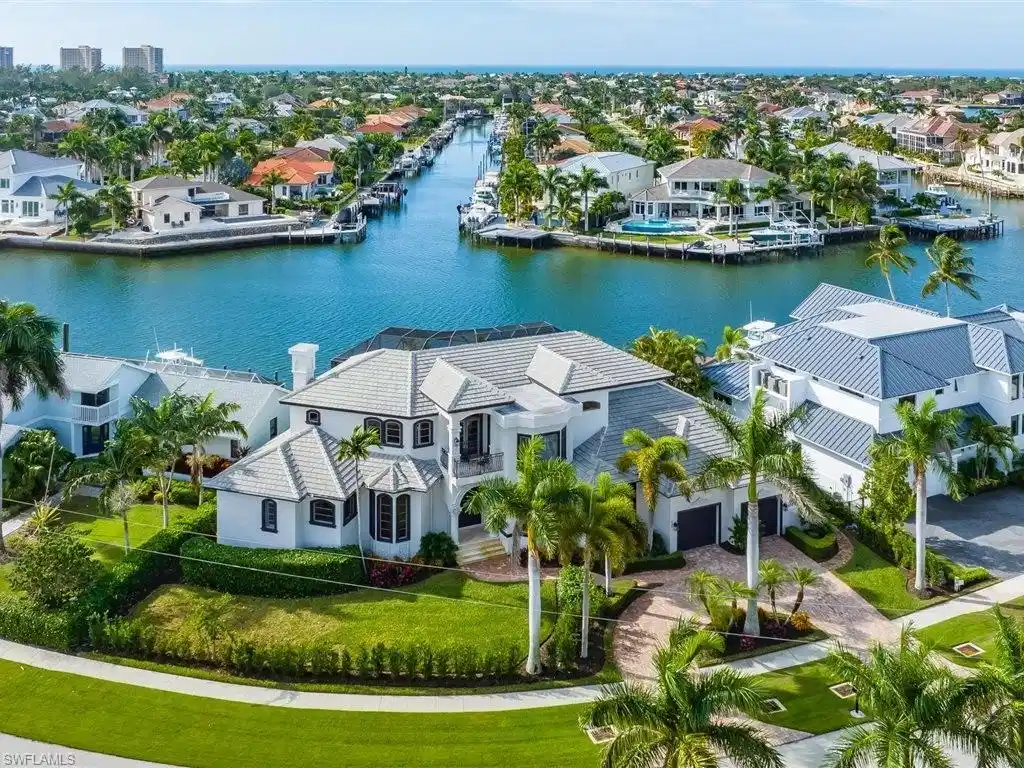 Image 1: Aerial view of residential area with a large body of water