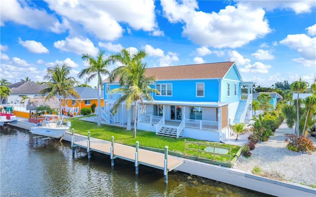 Image 3: Rear view of house featuring stairs, a porch, and a water view