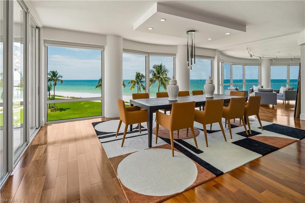 Image 2: Dining area featuring track lighting, hardwood / wood-style floors, and a water view