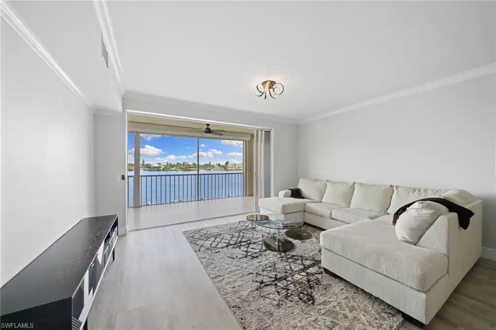 Image 1: Living area with a water view, light wood finished floors, and crown molding