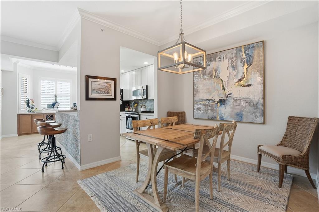 Image 1: Dining room featuring light tile patterned floors, crown molding, and a chandelier