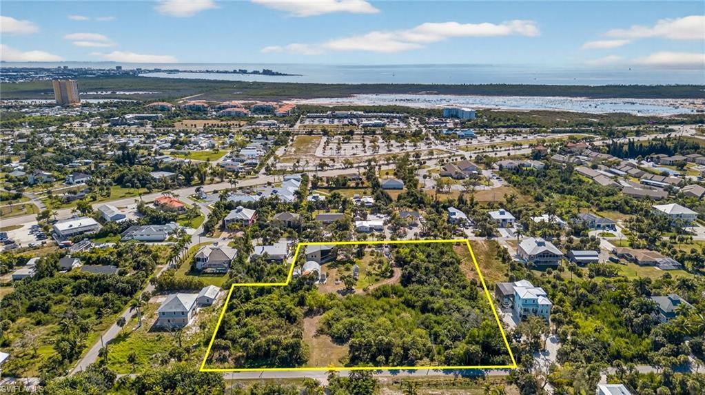 Image 3: Aerial view of residential area with property parcel outlined and a nearby body of water