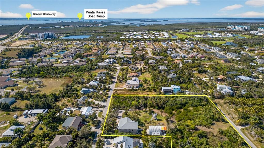 Image 4: Aerial view of residential area with a nearby body of water and property boundaries highlighted