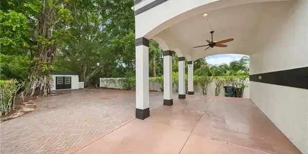 Image 3: Covered entry with arched architectural details and ceiling fan