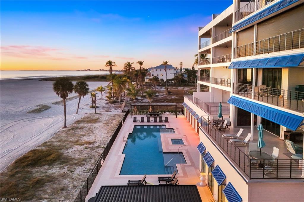 Image 2: Community pool featuring a patio area, a water view, and outdoor dining area - Virtually Edited Image