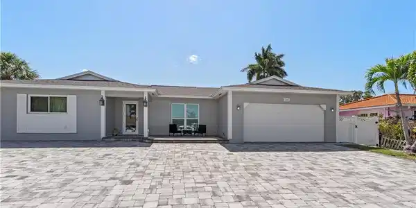 Image 3: Ranch-style home featuring an attached garage, decorative driveway, stucco siding, and a gate