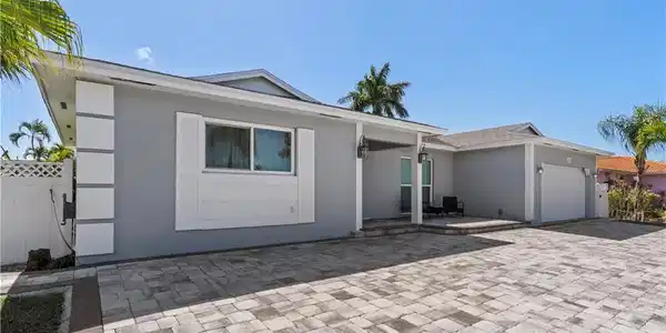 Image 4: Ranch-style house with an attached garage, stucco siding, driveway, and a patio area