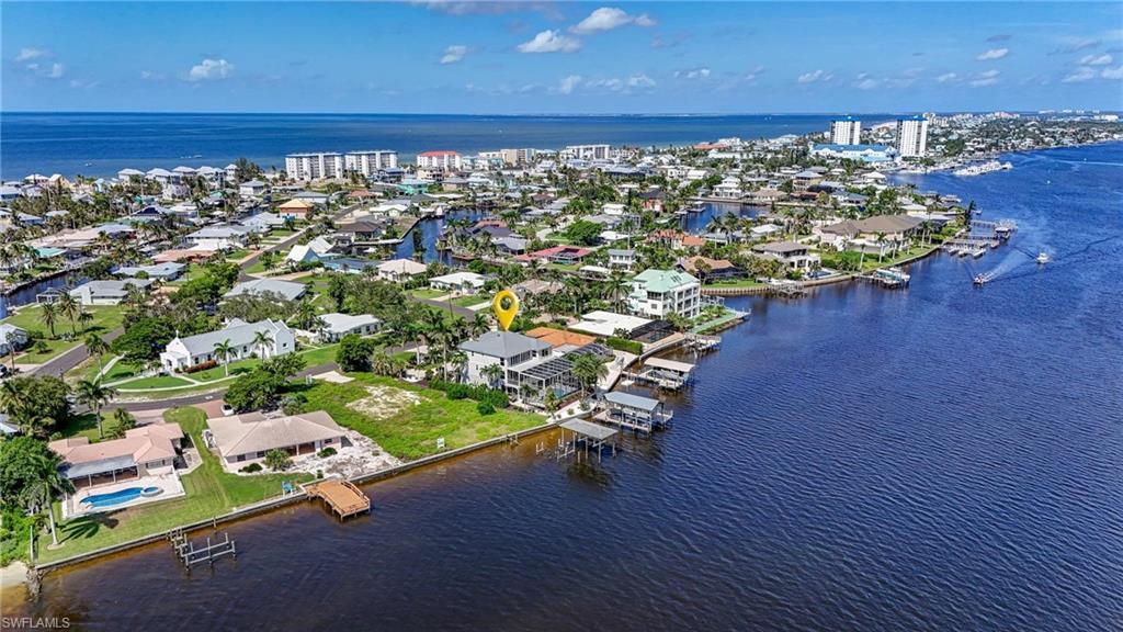 Image 3: Aerial perspective of suburban area featuring a nearby body of water - Virtually Edited Image