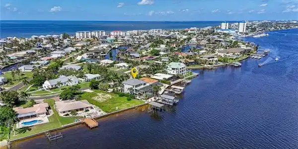 Image 3: Aerial perspective of suburban area featuring a nearby body of water - Virtually Edited Image