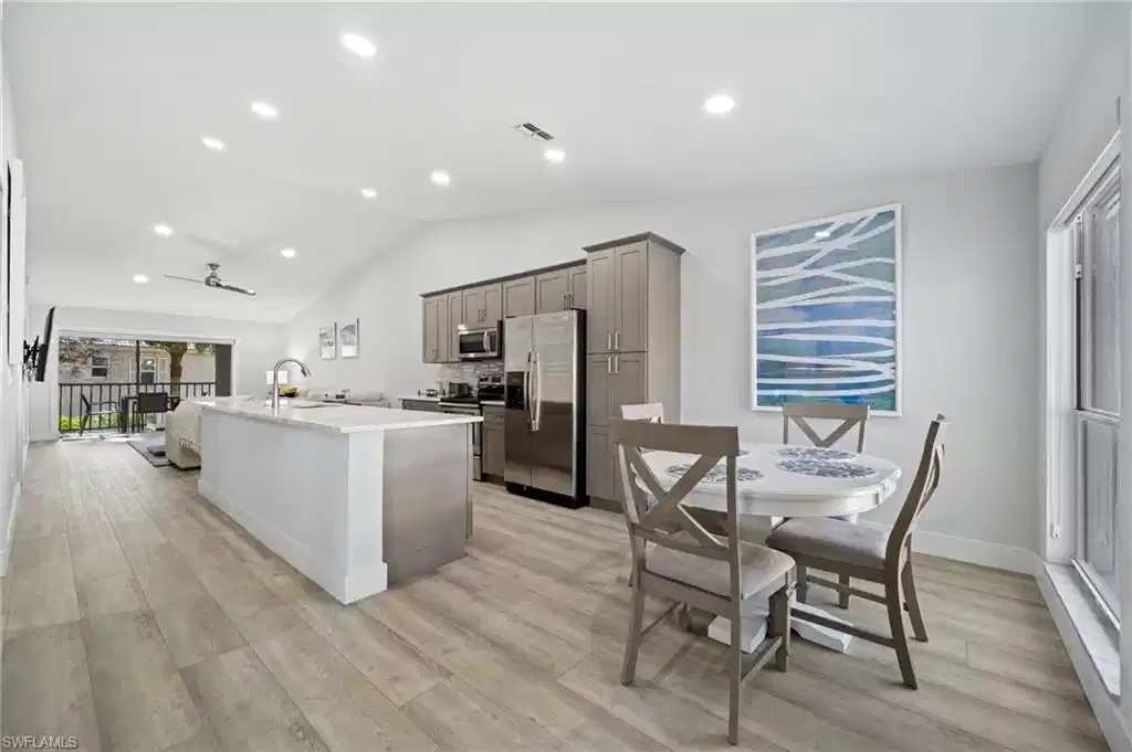 Image 1: Kitchen featuring gray cabinetry, stainless steel appliances, a center island with sink, recessed lighting, and ceiling fan